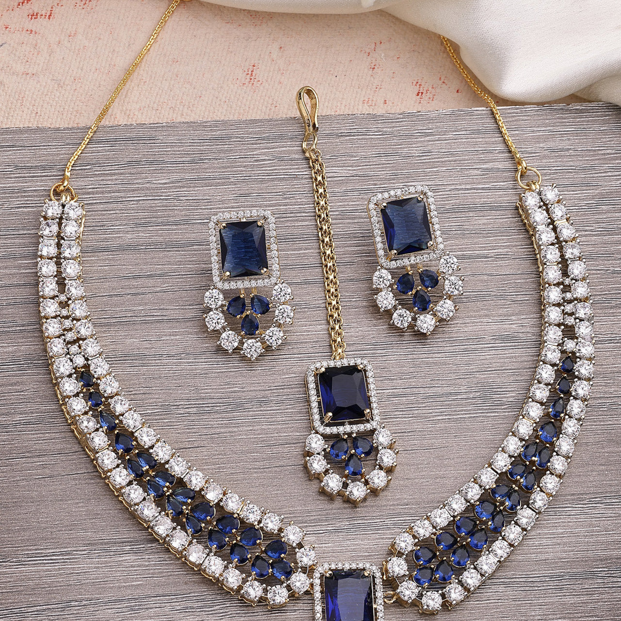 Sukkhi Sparkling Royal Blue Gold Plated with Cubic Zirconia Studded Brass Collar Necklace with Studs Earring & Maangtikka Jewellery Set for Women